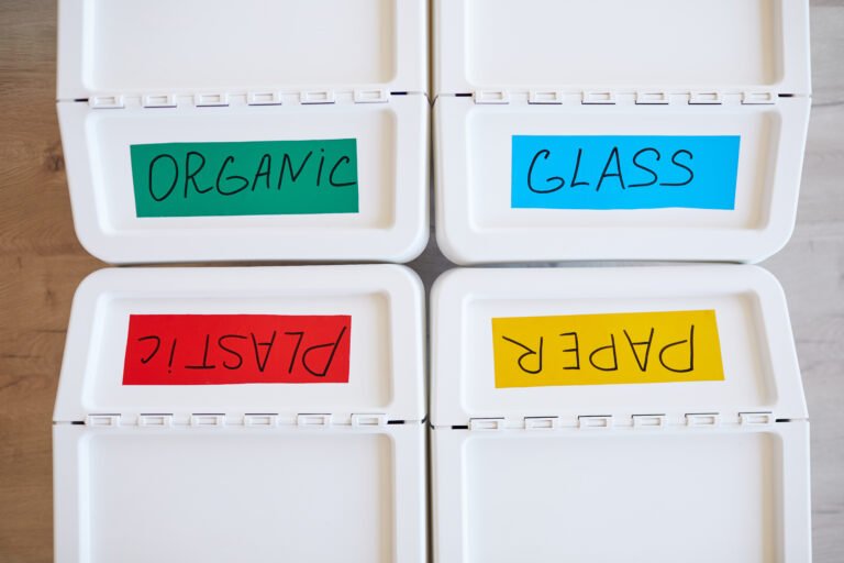 Top view background image of four plastic bins labeled for storage and sorting waste at home, copy space