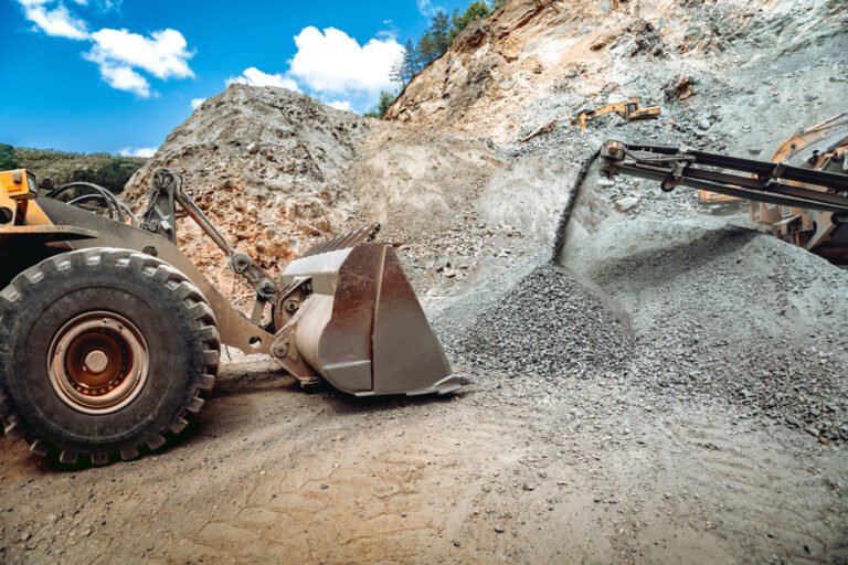 Heavy duty wheel loader excavator working in ore quarry. Mining industry. Industrial vehicles on construction site